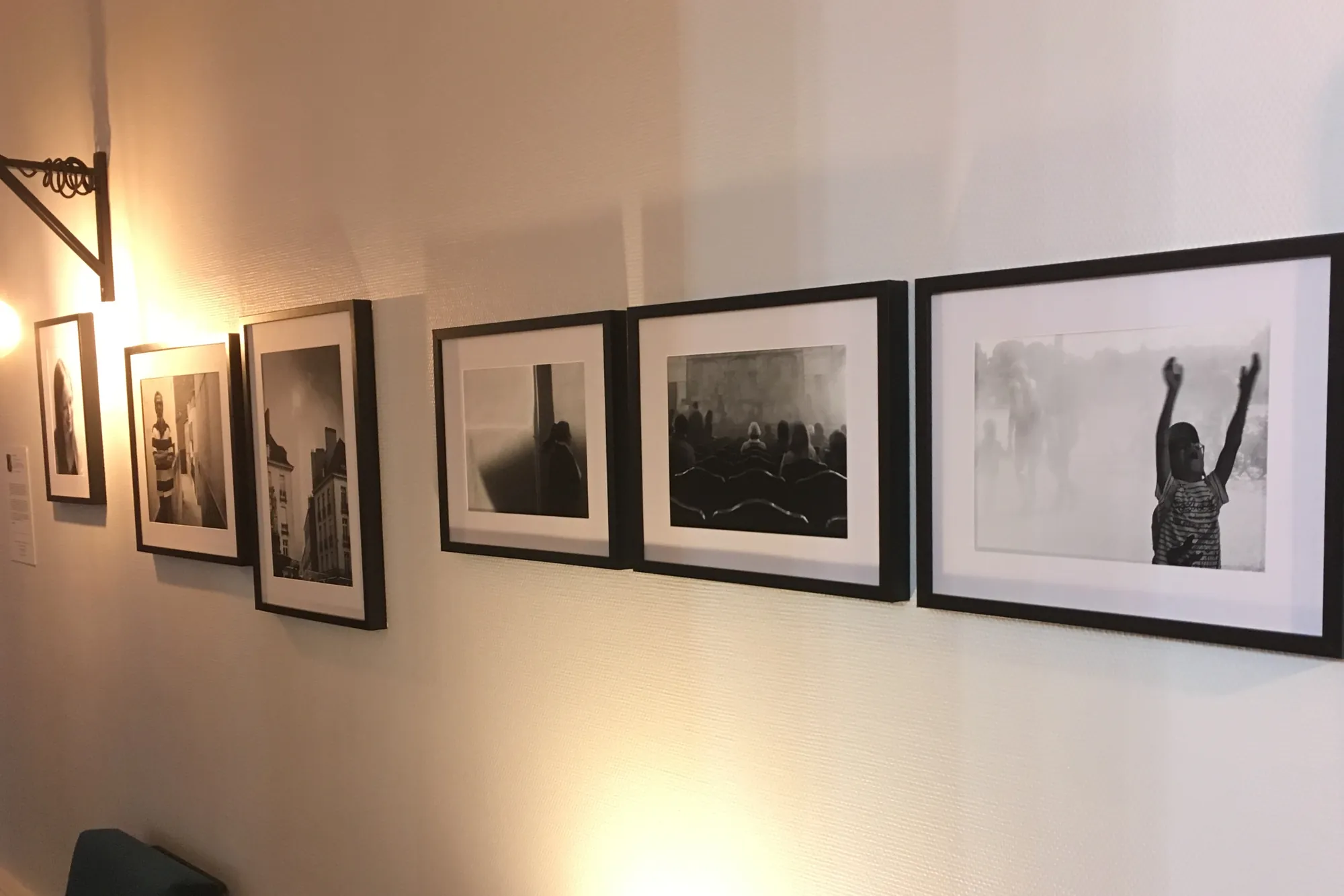 Ce que tu caches… : une rangée de tirages encadrés le long d’un mur